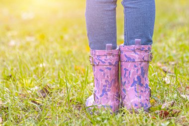 Çocuk ayak kauçuk botlar sararmış Kuru Çim üzerinde sonbahar