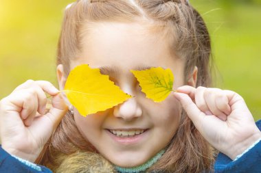 yüzünde sarı yapraklar kızla. gülümsüyor