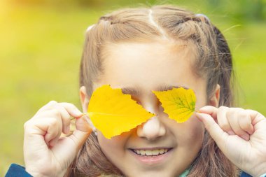 yüzünde sarı yapraklar kızla. gülümsüyor