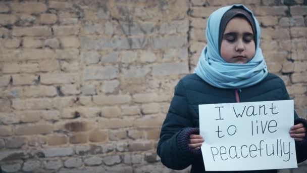 难民女孩与白色的床单上的题词 我想和平地生活 — 图库视频影像