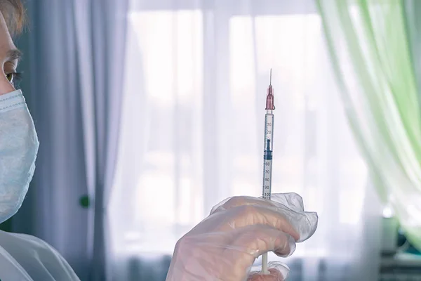 Žena v bílém kabát s injekční stříkačkou v ruce — Stock fotografie