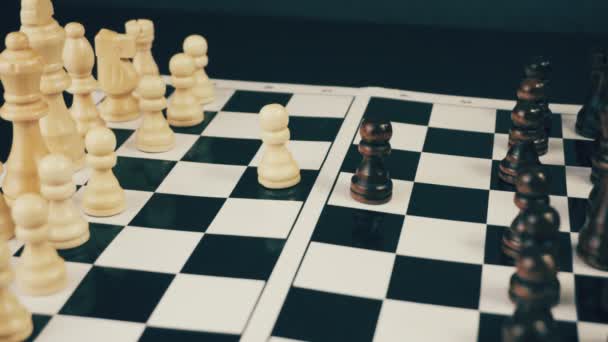 彼の手のゲームのチェス盤に白と黒のチェス — ストック動画