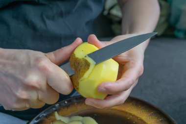 kadınların elleri patates soyma