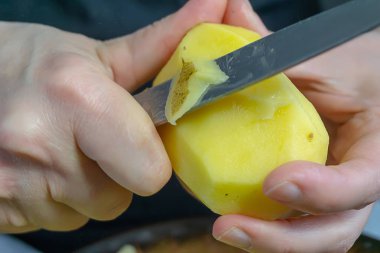 kadınların elleri patates soyma