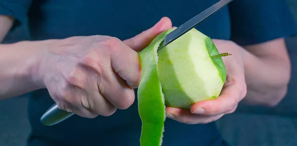 Дівчина очищає зелене яблуко — стокове фото