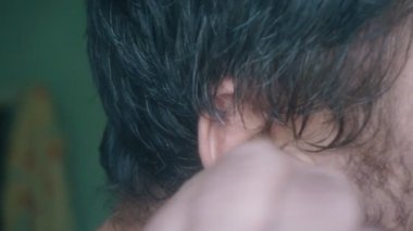 Orta yaşlı adam kulak yakın çekim temizler. kulaklar için bir değnek ile kulak fırçası. Eski bir beyaz adamın büyük kulağı bir kulak çubuğu ile temizlenir..