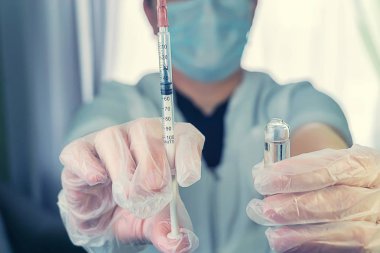 bir kadın bir beyaz ceket bir şırınga el