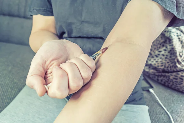 Joven adicta con una jeringa en la mano — Foto de Stock
