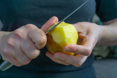 kadınların elleri patates soyma