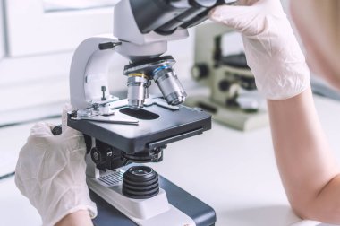 Laboratuvarda mikroskop ile eller