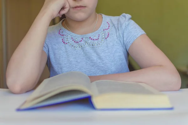 Niño leyendo un libro en la mesa — Foto de Stock