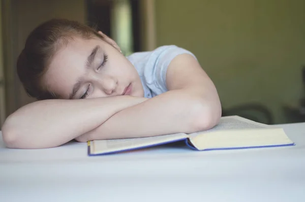 Niño leyendo un libro en la mesa — Foto de Stock