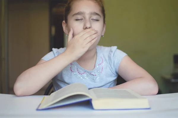 Niño leyendo un libro en la mesa — Foto de Stock