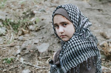 savaşta bir mülteci çocuk, harabeler üzerinde kirli bir yüzü olan Müslüman bir kız, barış ve savaş kavramı, çocuk ağlıyor ve yardım bekliyor.
