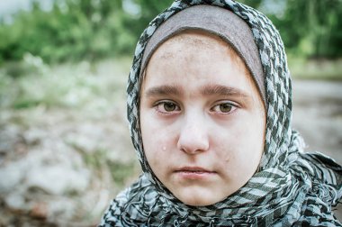 savaşta bir mülteci çocuk, harabeler üzerinde kirli bir yüzü olan Müslüman bir kız, barış ve savaş kavramı, çocuk ağlıyor ve yardım bekliyor.