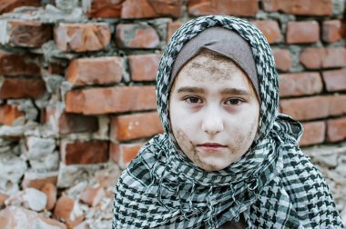 savaşta bir mülteci çocuk, harabeler üzerinde kirli bir yüzü olan Müslüman bir kız, barış ve savaş kavramı, çocuk ağlıyor ve yardım bekliyor.