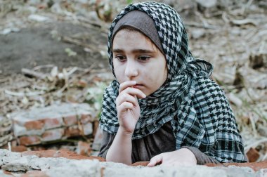savaşta bir mülteci çocuk, harabeler üzerinde kirli bir yüzü olan Müslüman bir kız, barış ve savaş kavramı, çocuk ağlıyor ve yardım bekliyor.