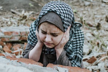 savaşta bir mülteci çocuk, harabeler üzerinde kirli bir yüzü olan Müslüman bir kız, barış ve savaş kavramı, çocuk ağlıyor ve yardım bekliyor.