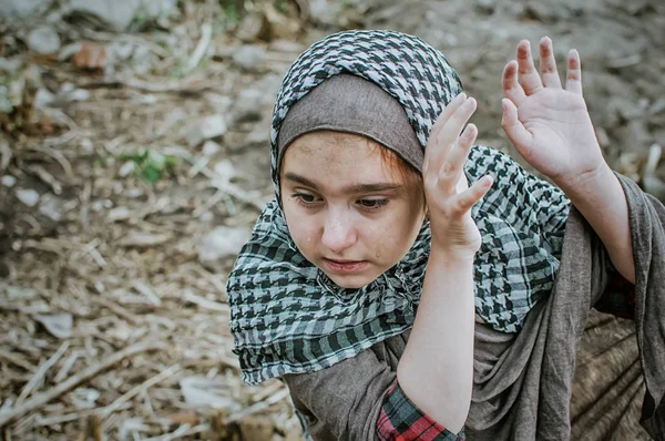 savaşta bir mülteci çocuk, harabeler üzerinde kirli bir yüzü olan Müslüman bir kız, barış ve savaş kavramı, çocuk ağlıyor ve yardım bekliyor.