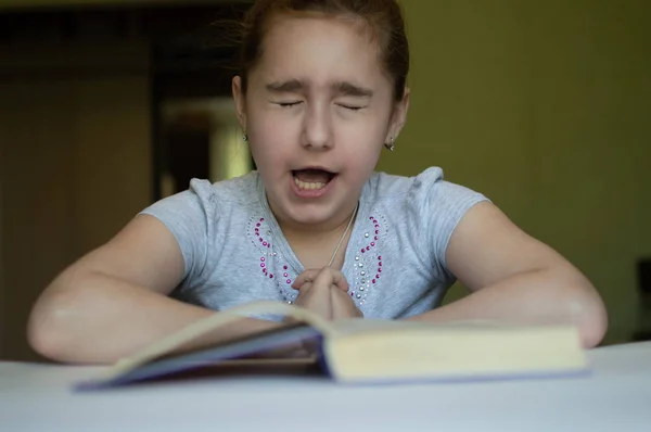 Niño leyendo un libro en la mesa — Foto de Stock