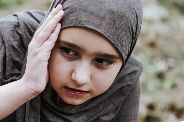 Un niño refugiado en la guerra, una niña musulmana con una cara sucia en las ruinas, el concepto de paz y guerra, el niño está llorando y esperando ayuda . —  Fotos de Stock