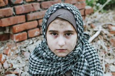 savaşta bir mülteci çocuk, harabeler üzerinde kirli bir yüzü olan Müslüman bir kız, barış ve savaş kavramı, çocuk ağlıyor ve yardım bekliyor.
