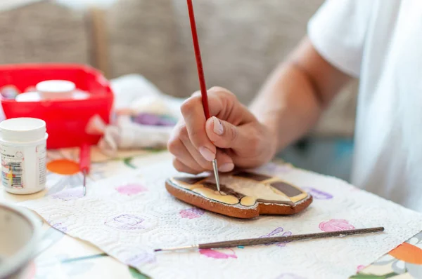 Primer plano de la pintura de manos de confitero con pincel sobre pan de jengibre — Foto de Stock