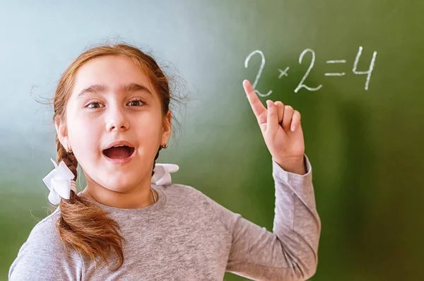 Schoolmeisje lost een wiskundig probleem op de Blackboard tijdens de les. — Stockfoto