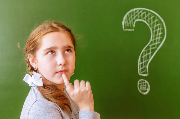 Portret van een schoolmeisje dat denkt over het oplossen van een probleem op het Blackboard tijdens de les. — Stockfoto