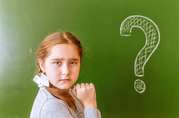 Портрет школьницы, размышляющей о решении проблемы на доске во время урока . — стоковое фото