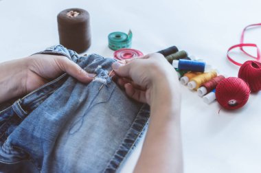 kadın elleri, bir terzi iplik makaraları yalan bir masada elbise diker