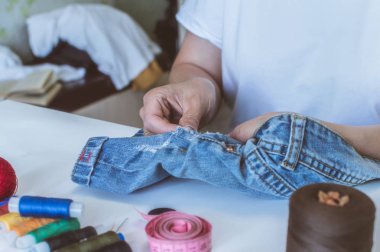 kadın elleri, bir terzi iplik makaraları yalan bir masada elbise diker