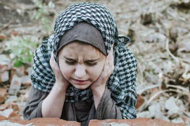 savaşta bir mülteci çocuk, harabeler üzerinde kirli bir yüzü olan Müslüman bir kız, barış ve savaş kavramı, çocuk ağlıyor ve yardım bekliyor.