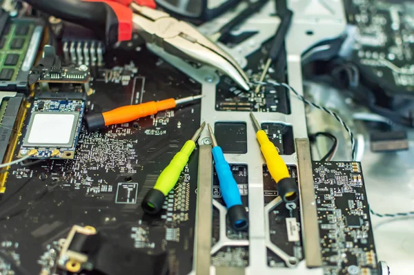 a man repairs a computer, solders a board, repairs electronics and modern technologies
