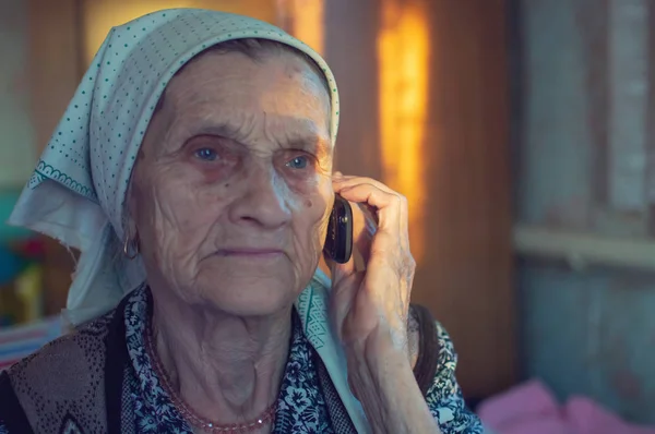 old woman in a headscarf with an old telephone in a nursing home. close-up.