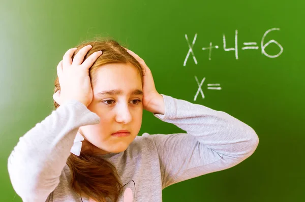 Schoolmeisje lost een wiskundig probleem op de Blackboard tijdens de les. — Stockfoto