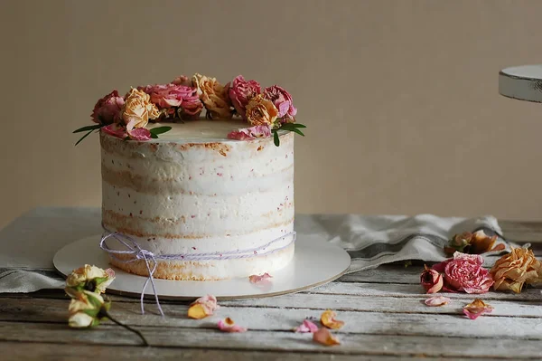 木のテーブルの上に新鮮な花で飾られた白いクリームケーキ 横写真 選択的焦点 — ストック写真