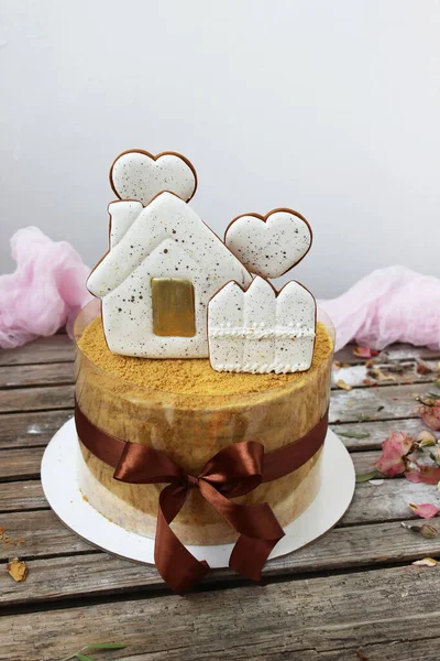 蜂蜜蛋糕 用姜饼屋装饰 放在一个用褐色缎带捆扎的蛋糕架上 有选择的重点 靠近点 — 图库照片