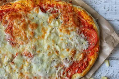 Geleneksel pizza Margarita evde ahşap bir masada hazırlanır. Kapat..