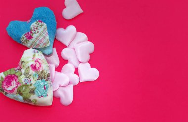 Kalpler, pembe arka planda bulunan farklı boyutlarda el yapımı kumaştan yapılmış ve yazıtlar için bir yer var. Yukarıdan manzara. İlişki ve aşk kavramı.