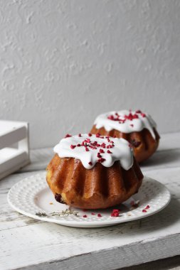 Rum baba beyaz bir masa örtüsüyle kaplı bir tabağa beyaz krema döktü. Kapat..