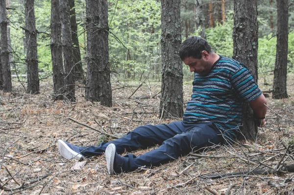 Morderstwo Lesie Ciało Mężczyzny Niebieskiej Koszulce Spodniach Siedzi Ziemi Pośród Obraz Stockowy