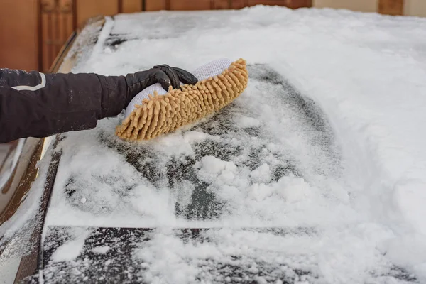 冬の悪天候 猛吹雪 雪の中から車の窓をきれいに柔らかいブラシを持つ男 — ストック写真