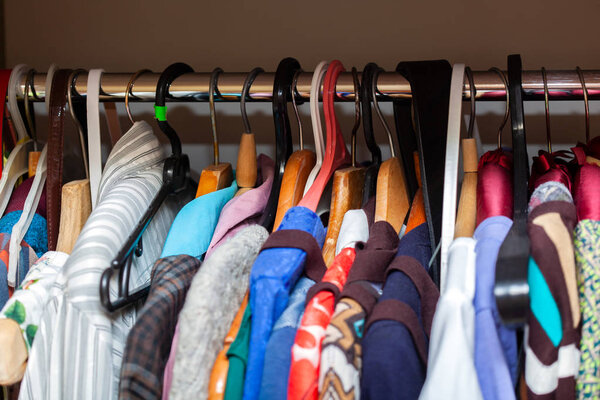 Hangers with different clothes in wardrobe