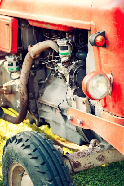 Un viejo tractor rojo en un campo agrícola . — Foto de Stock