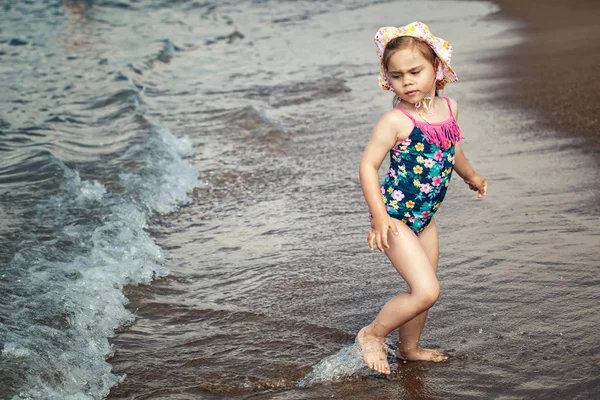 Enfant heureux courant et sautant dans les vagues — Photo