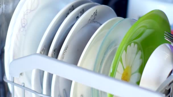 Человек вынимает посуду из посудомойки — стоковое видео