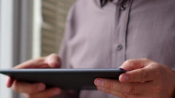 Un hombre que se divierte jugando en la tableta digital — Vídeo de stock