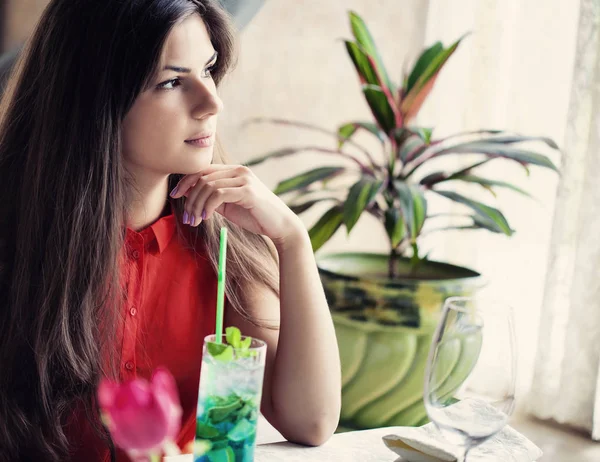 Portret van mooie jonge vrouw in café coctail drinken — Stockfoto