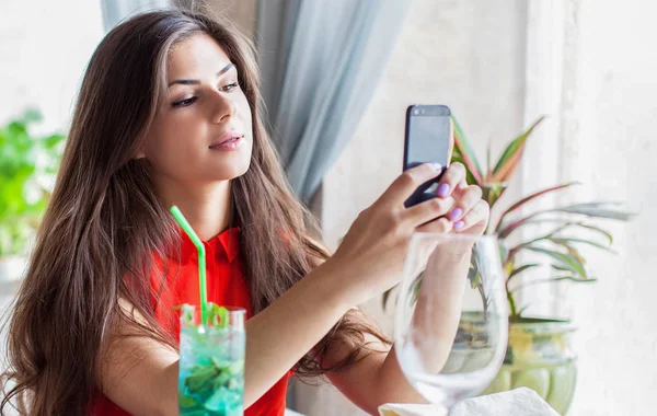 Porträtt av en ung attraktiv kvinna tar en selfie av sig själv — Stockfoto